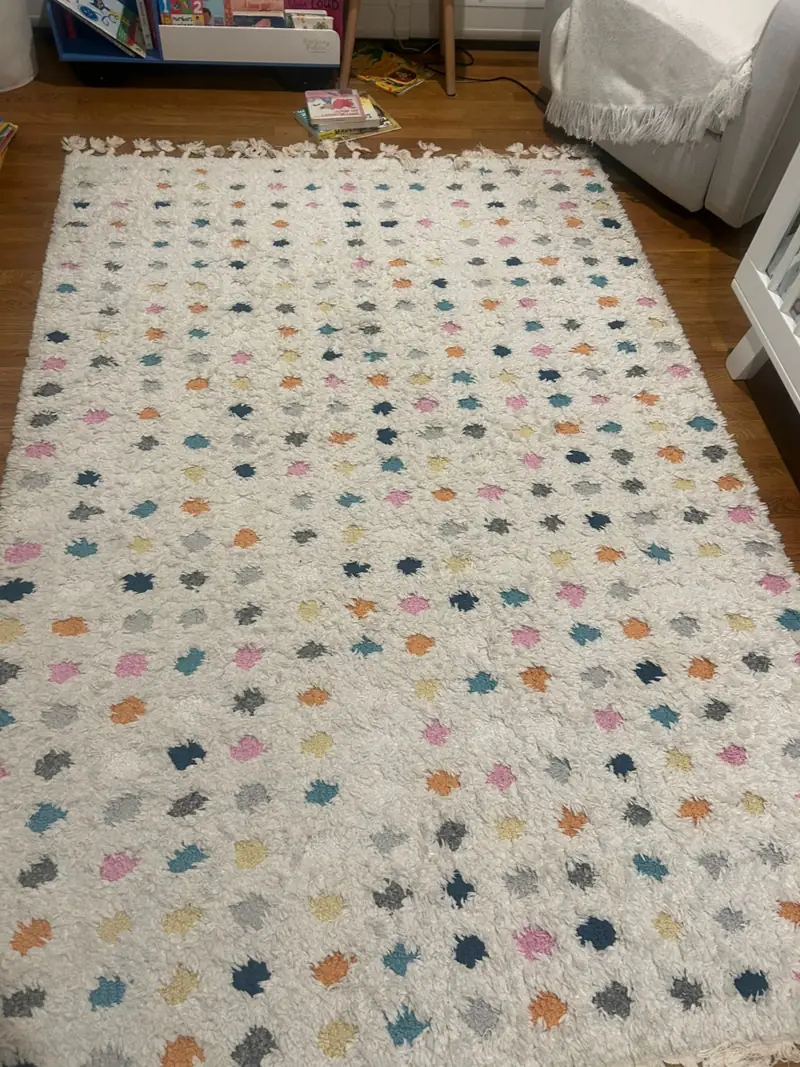 A white shag rug with small multicolored motifs