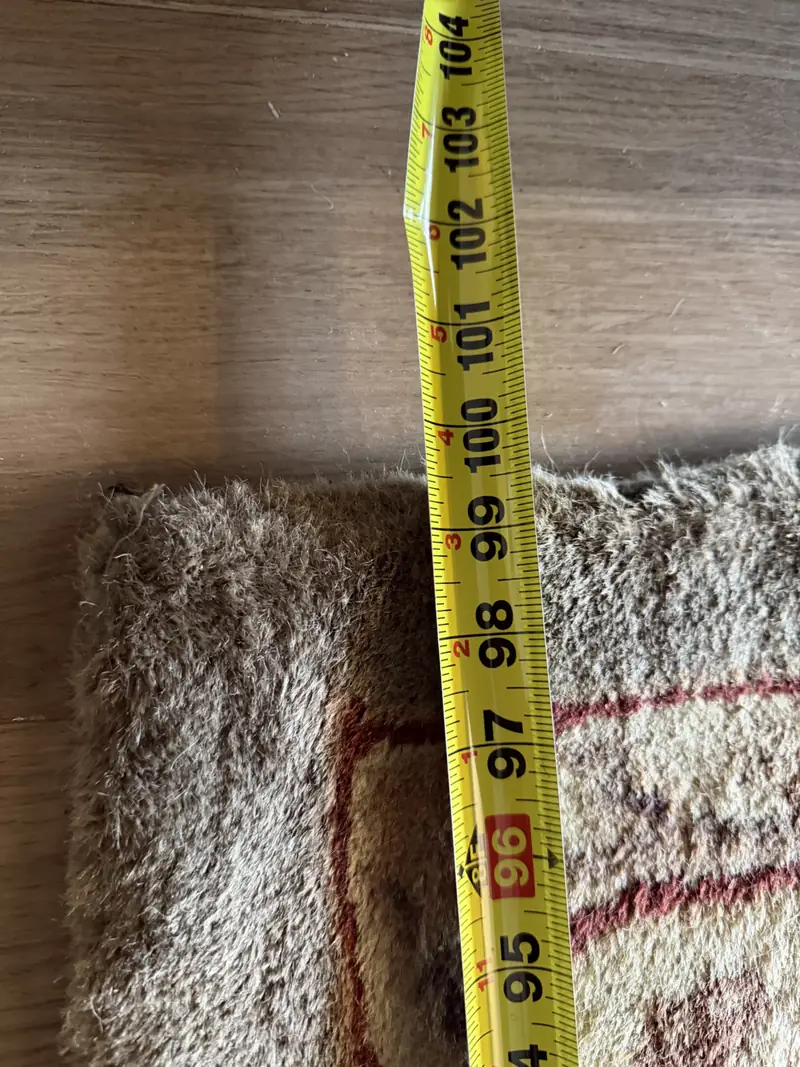 A tape measure across the pile at the edge of a rug