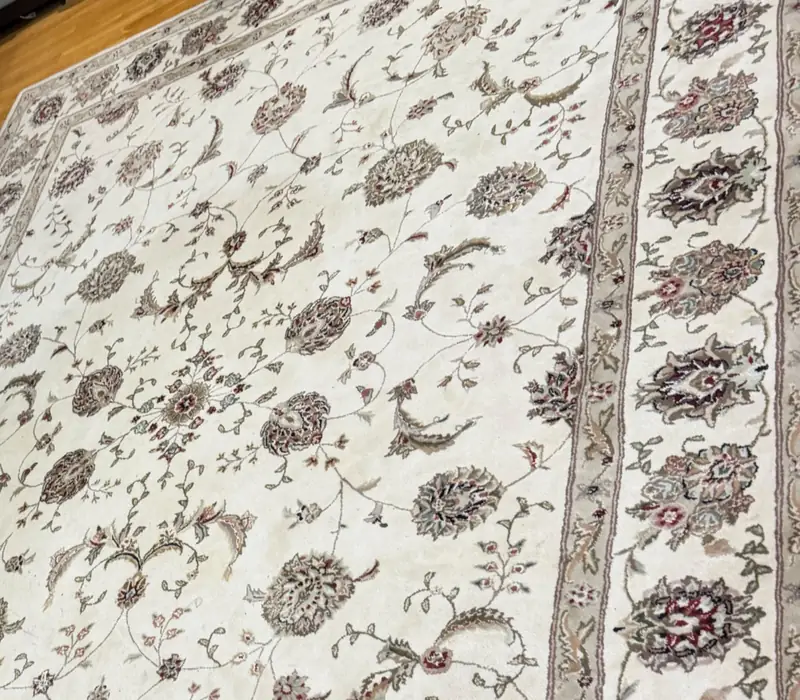 The ivory floral field of a finely patterned rug